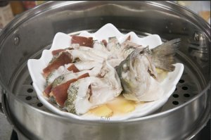 將鱸魚成花狀擺好，將火腿切片放入各縫隙中，放入鍋中隔水蒸12分鐘拿出，撒上蔥花即可。