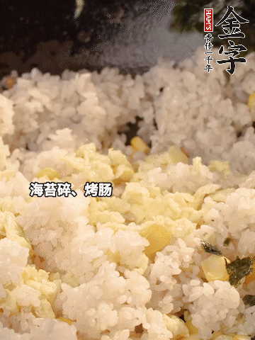 剩米飯下鍋炒散，依次下玉米粒、雞蛋、烤腸、海苔碎翻炒均勻。