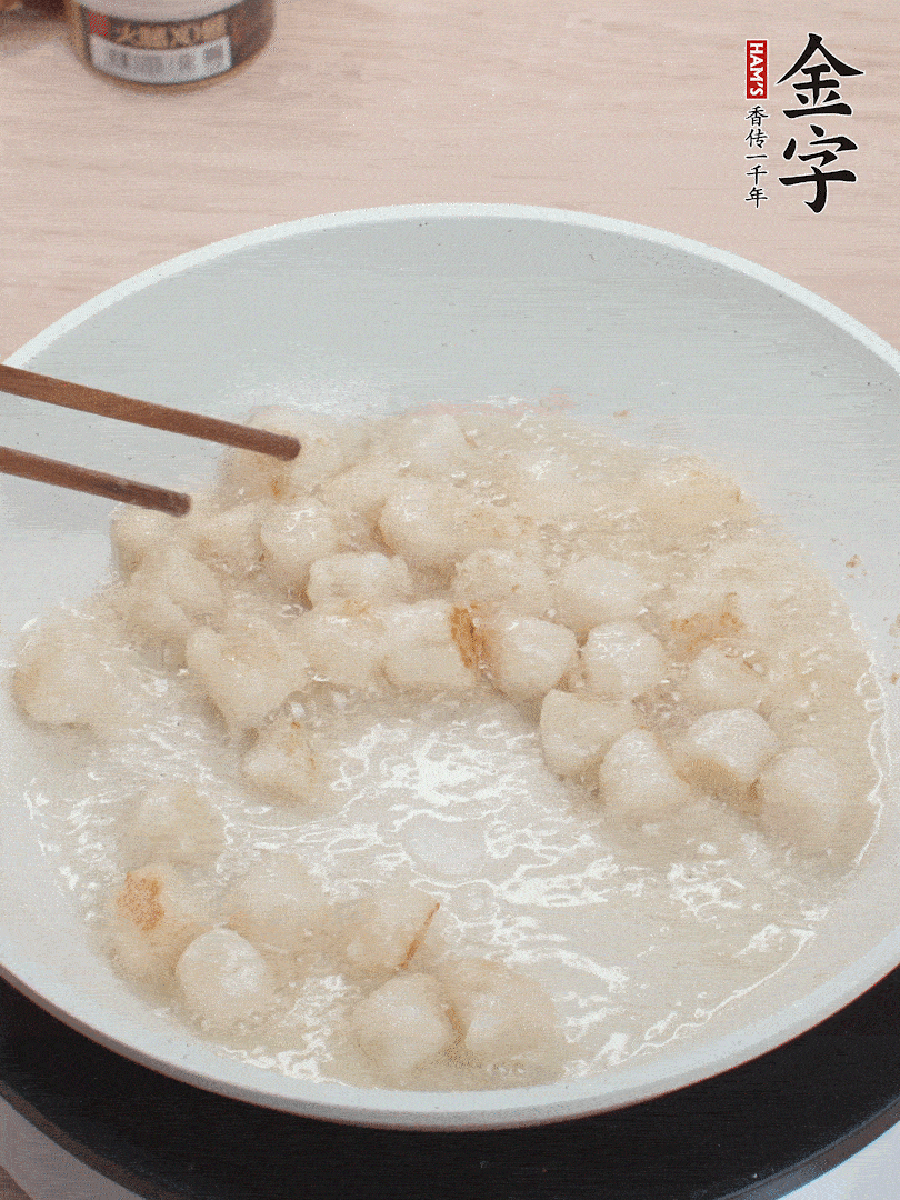 油溫4成熱，鮮貝蘸干淀粉下鍋煎，一面微黃后翻面。