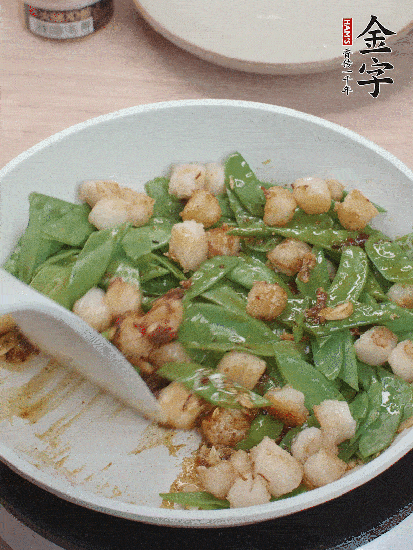 下甜豆莢、鮮貝輕輕翻炒均勻。