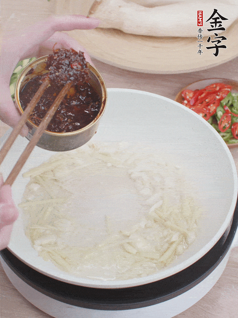 起鍋熱油，姜蒜、金字火腿干貝醬煸香。