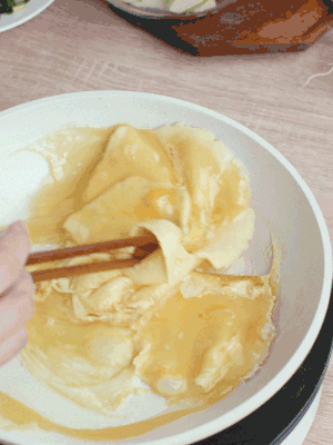 油6成熱時(shí)，下雞蛋液，邊緣凝固時(shí)翻拌成塊狀。